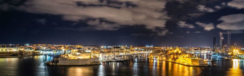 Sailboats moored in city at night