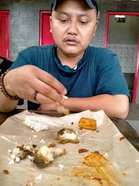 Midsection of man holding ice cream on table