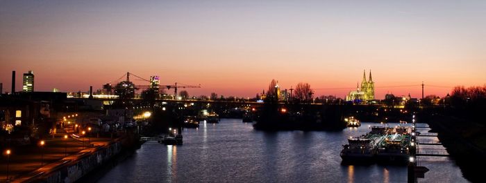 Boats moored at harbor during sunset