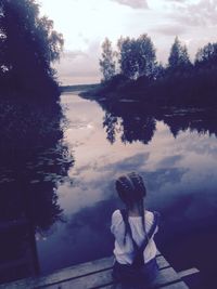 Woman standing by lake against sky