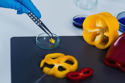 Cropped hands of scientist experimenting on bell peppers