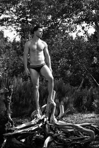 Full length of woman standing on tree trunk