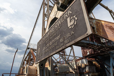 Low angle view of information sign against sky