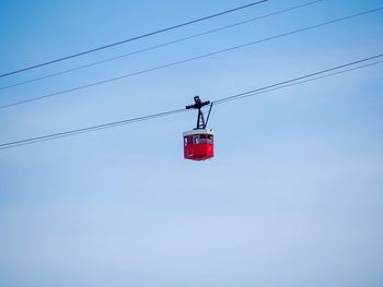 Low angle view of overhead cable car against sky