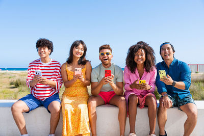 Friends sitting against clear sky