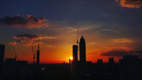 Silhouette cityscape against sky during sunset