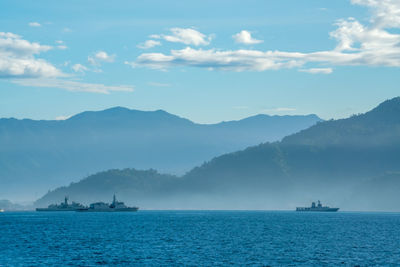 Scenic view of sea and mountains against sky