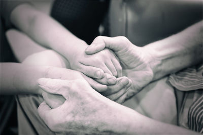 Midsection of grandmother holding granddaughter hand