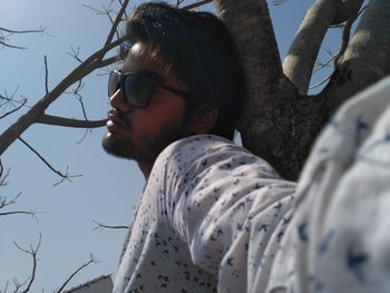 Portrait of young man wearing sunglasses against sky