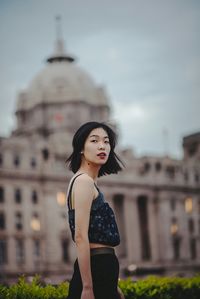 Young woman standing against built structure