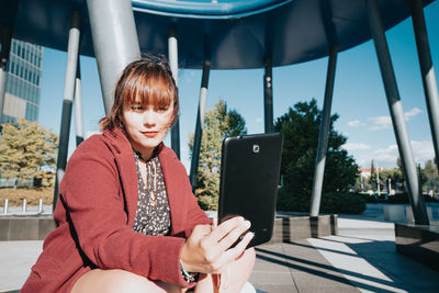 Portrait of young woman using digital tablet