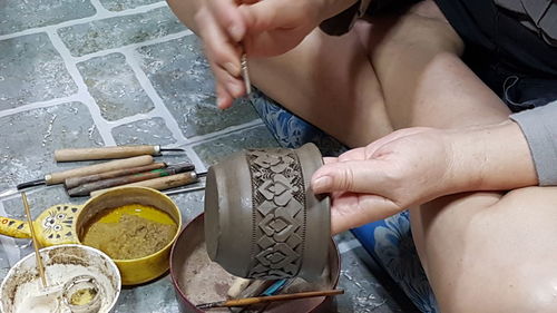 High angle view of woman decorating pottery 