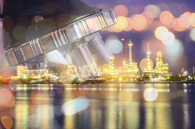 Double exposure image of microscope with illuminated city buildings at night