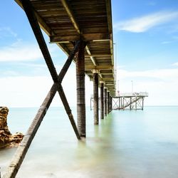 Silhouette pier over sea against sky
