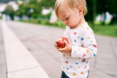 Cute girl holding ice cream standing outdoors