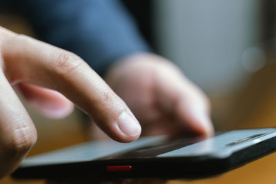 Midsection of man using mobile phone