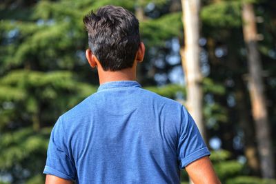 Rear view of man standing against blurred background