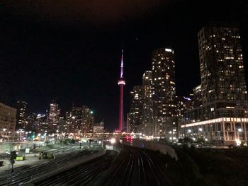 Illuminated buildings in city against sky at night