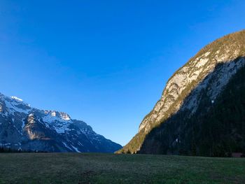 Scenic view of snowcapped mountains against clear blue sky