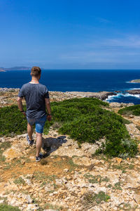 Full length of man looking at sea against sky