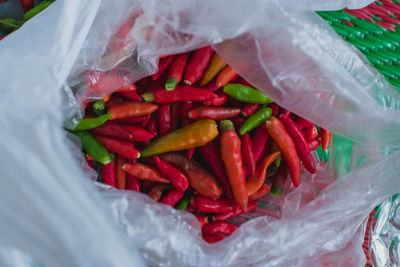 Close-up of red chili peppers in plastic container