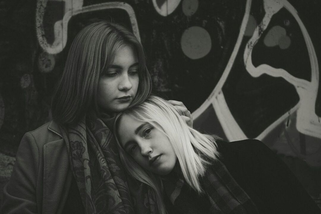 young women, young adult, real people, two people, lifestyles, portrait, couple - relationship, leisure activity, love, togetherness, graffiti, women, emotion, casual clothing, people, front view, adult, headshot, heterosexual couple, teenager, positive emotion, hairstyle, contemplation, beautiful woman