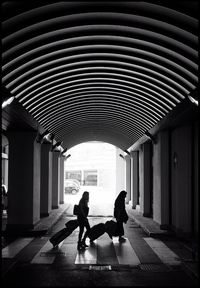 Women with luggage walking towards building