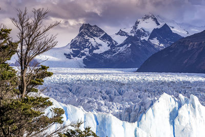 Scenic view of glacier with snow covered mountains