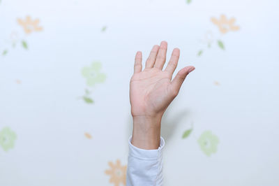 Close-up of man hand gesturing against wall