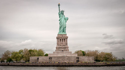 View of statue of liberty against cloudy sky