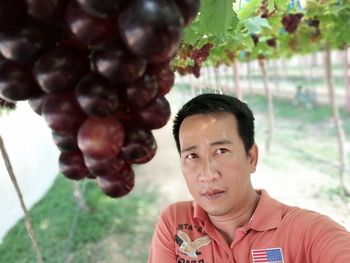 High angle view of man looking away while standing in vineyard