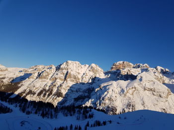 Scenic view of snowcapped mountains against clear blue sky