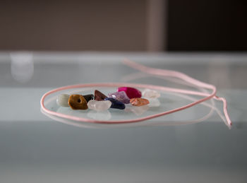 Close-up of gemstones and string on table