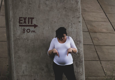 Full length of young man standing against wall