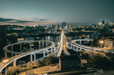 High angle view of illuminated cityscape against sky at night