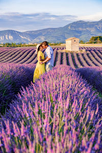 Rear view of couple on field against sky