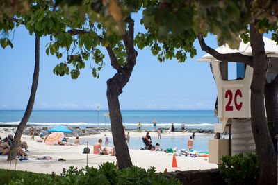 People at beach against blue sky