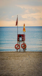 Scenic view of sea against sky during sunset with lifeguard tower