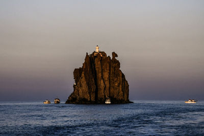 Scenic view of rock formation in sea against sky