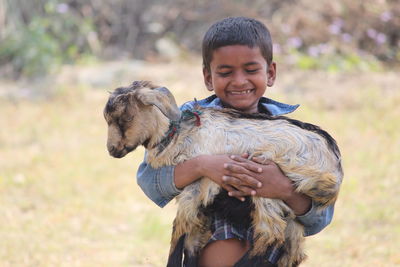 Boy holding goat