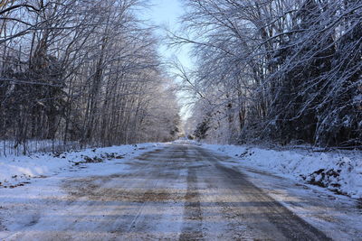 Road amidst snow covered trees during winter