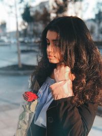 Young woman looking away while standing on plant during winter