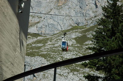 High angle view of overhead cable car amidst trees and mountains