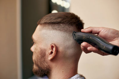 Side view of man using mobile phone at home