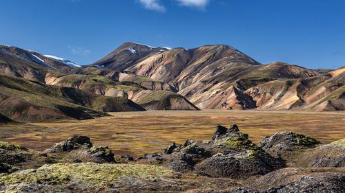 Scenic view of land and mountains against sky