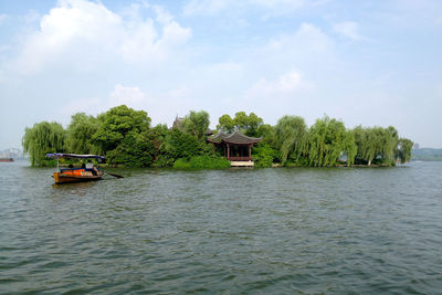 View of boats in calm sea against trees