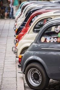 Close-up of cars parked on road