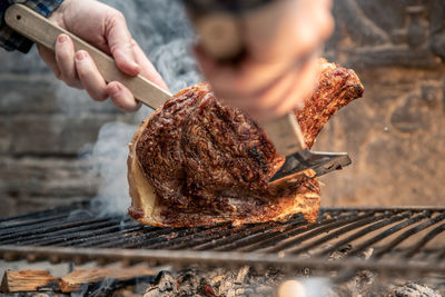 Italian roasted steak on a barbeque grill appetizing meat cooking on fire and embers in the backyard