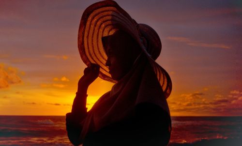 Woman looking at sea during sunset