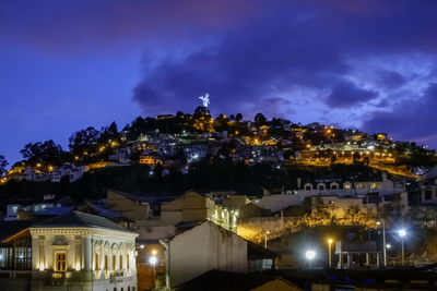 Illuminated buildings in city against sky